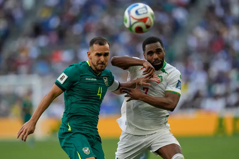 Luis Haquín peleando un balón con jugador de Surinam l AP