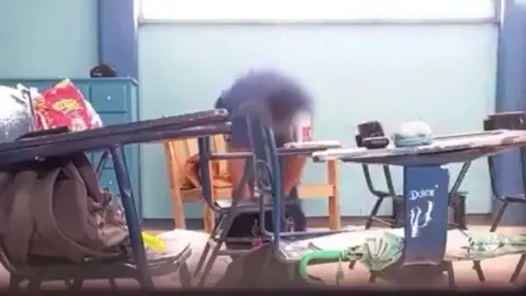 Las imágenes muestran al maestro revisar las mochilas de sus alumnos / Especial