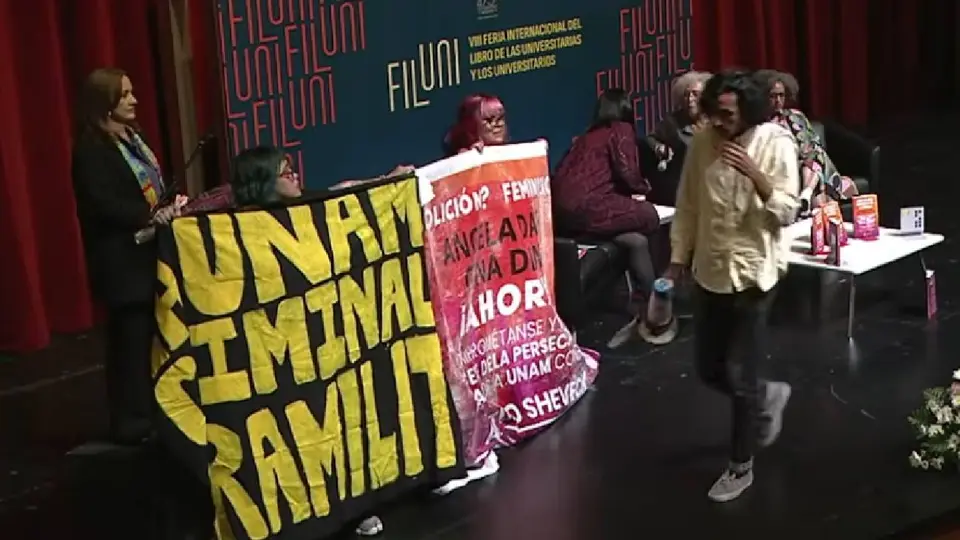 Asistentes se manifiestan en la Sala Miguel Covarrubias antes del inicio de la conferencia / Captura de pantalla