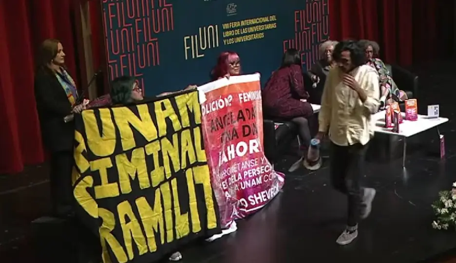 Asistentes se manifiestan en la Sala Miguel Covarrubias antes del inicio de la conferencia / Captura de pantalla