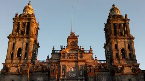 Hombre sube a la Catedral de la CDMX para hablar con AMLO