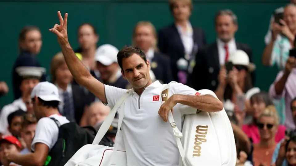 Padre de Roger Federer le ayuda a firmar autógrafos