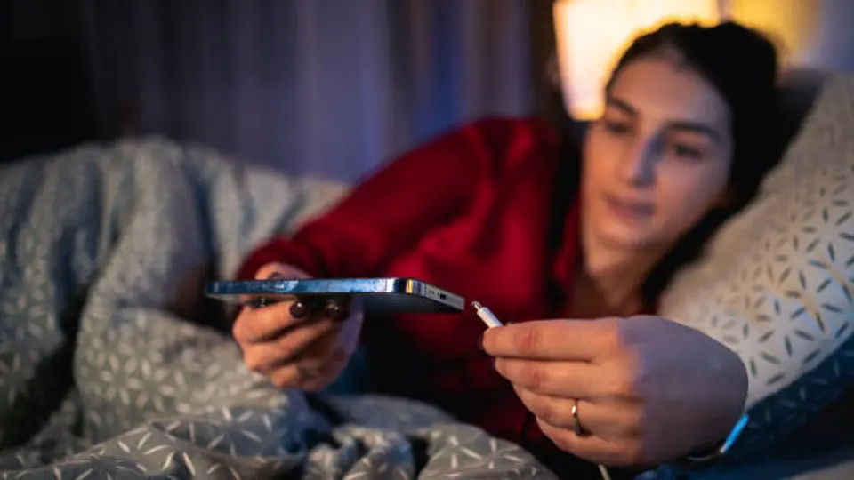 Cargar el celular sobre la cama o almohadas puede impedir la ventilación adecuada. / iStock