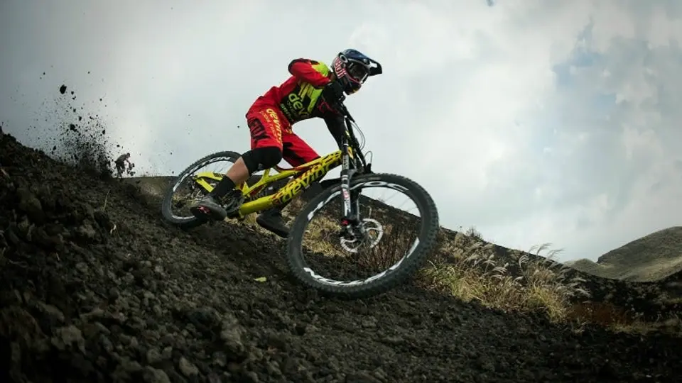 Ciclista realiza descenso de montaña en volcán activo