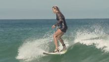 Mujer surfea con tacones y vestido