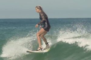 Mujer surfea con tacones y vestido