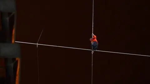 Hombre cruza rascacielos caminando sobre un cable
