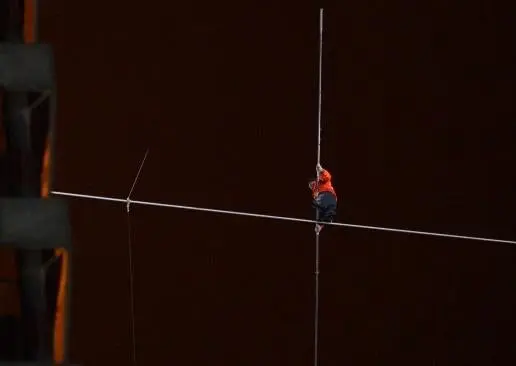 Hombre cruza rascacielos caminando sobre un cable