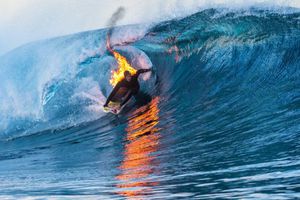 Surfista domina las olas envuelto en llamas
