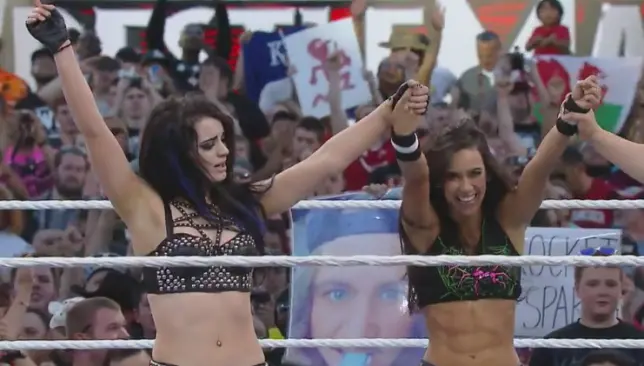 Paige y AJ levantan la mano luego de derrotar a la gemela Bella | WWE