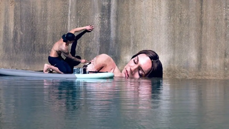 Artista pinta murales sobre una tabla de surf