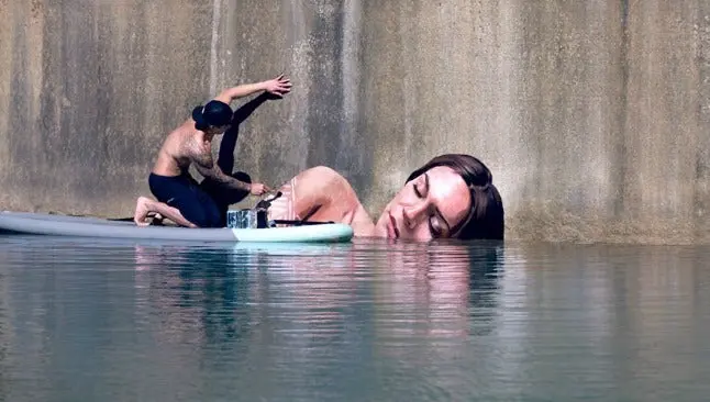 Artista pinta murales sobre una tabla de surf