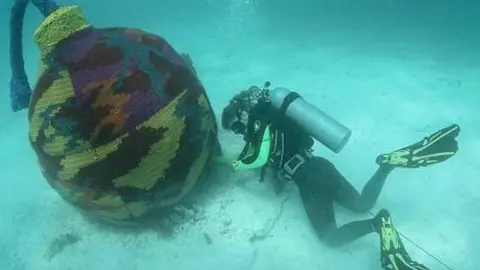 Artista decora esculturas en museo submarino