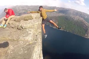 Joven cuelga de acantilado sólo con un brazo