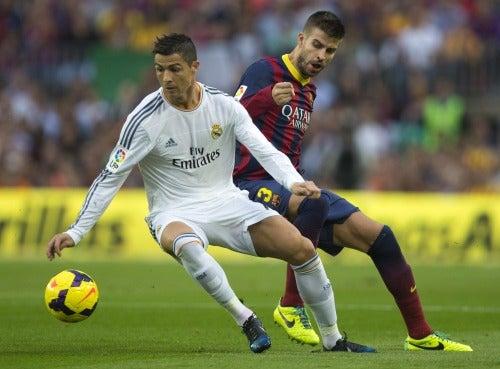 Cristiano Ronaldo intenta eludir la marca de Gerard Piqué | EFE