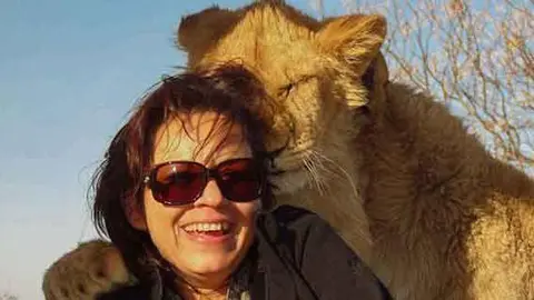 Leona 'abraza' a turista para la foto