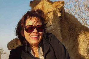 Leona 'abraza' a turista para la foto