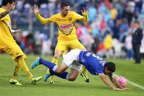 Layún levanta las manos para evitar el contacto con el jugador celeste que cae | EFE