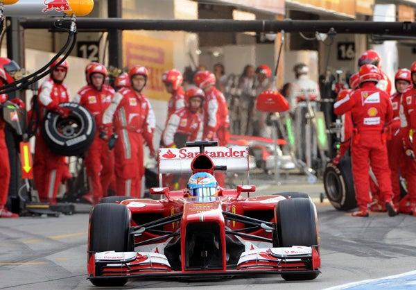 Alonso sale de pits ante la mirada de su equipo | AP