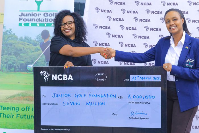 Nelly Wainaina (L) presents the sponsorship to JGF president Regina Gachora
