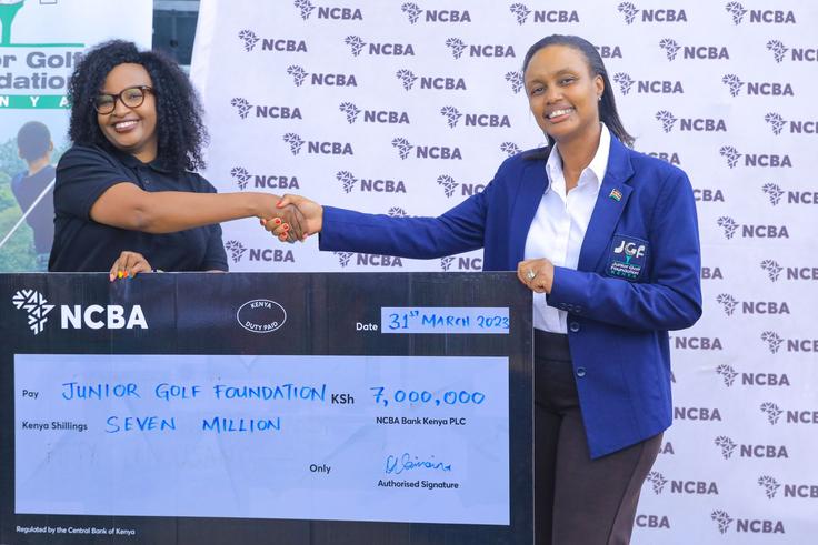 Nelly Wainaina (L) presents the sponsorship to JGF president Regina Gachora