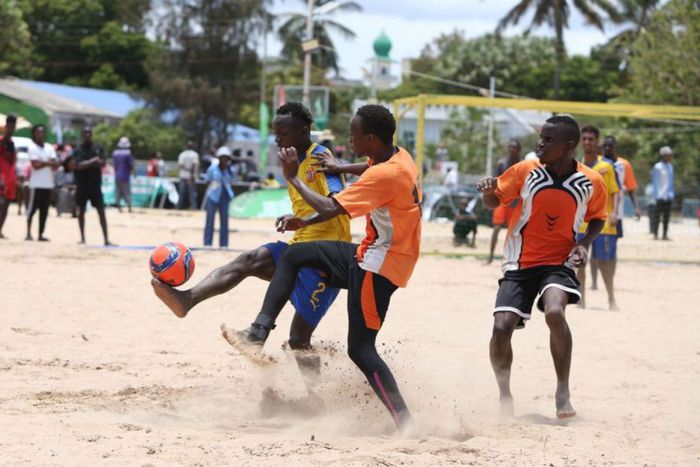 Football players in action during the Kenya Beach Games