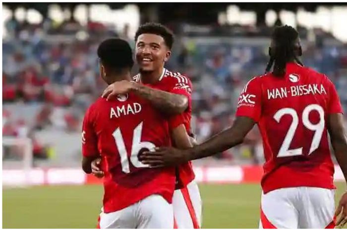 Amad gets a warm embrace from Jadon Sancho after his goal.