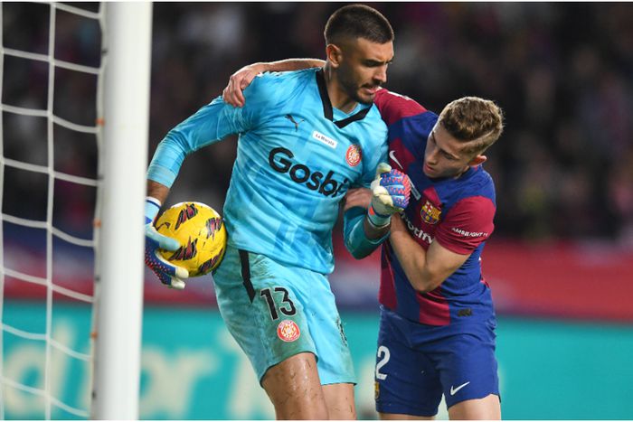 Barcelona's Ferran Torres fights Girona's goalkeeper for the ball.