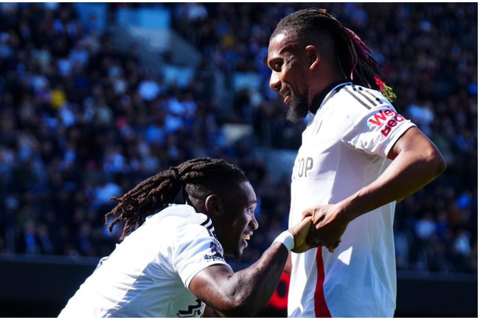 Calvin Bassey celebrates with Alex Iwobi after his milestone display for Fulham against Liverpool.