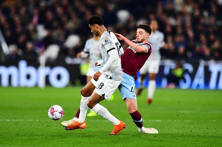 Declan Rice challenges Liverpool forward Cody Gakpo for the ball