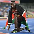 Ferdinand Omanyala celebrating with the Kenyan flag on his back.