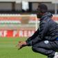 Sofapaka head coach David Ouma squatting on the touchline.