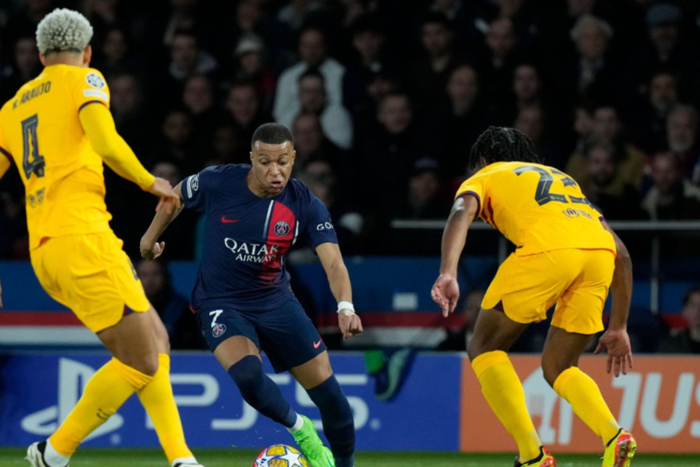Kylian Mbappe (7) (Paris St Germain (PSG)) tries to pass Ronald Araujo and Jules Kounde during the Champions League match between Paris Saint-Germain (PSG) and FC Barcelona, Barca at Parc des Princes. (Photo by Glenn Gervot/Icon Sportswire)