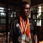 Eliud Kipchoge posing for a photo with his medals.