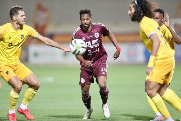 Al Faisaly forward Masud Juma dribbling past two players.