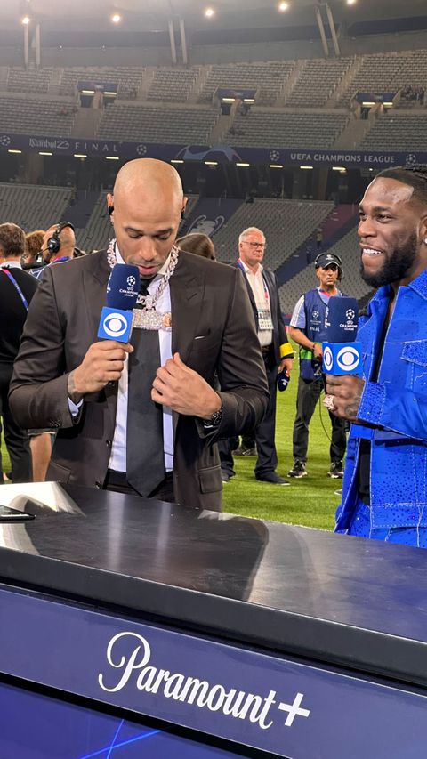 Burna Boy took off his "Gambo" diamond necklace and put it around Thierry Henry's neck while being interviewed following the Champions League match between Manchester City and Inter Milan.