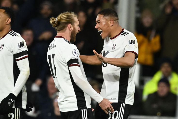 Fulham striker Carlos Vinicius (R) celebrates with Tim Ream (C) after scoring their second goal against Chelsea