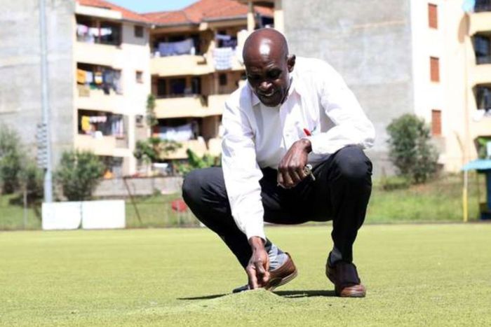 Kenya Hockey Union president Nahashon Randiek shows part of the damaged artificial turf at City Park Stadium in Nairobi on December 11, 2020