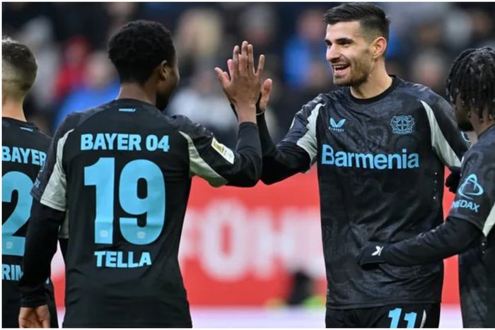 Nathan Tella celebrates with his Leverkusen teammates.