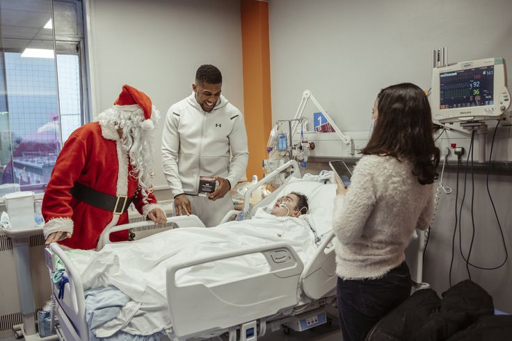 Nigeria-born boxer Anthony Joshua and Father Christmas visit to give gifts to kids at Watford hospital.