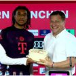 Max Eberl presents the cake to Michael Olise during his presentation as new Bayern Munich player.