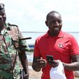 NOC-K Secretary General Francis Mutuku standing next to a policeman.