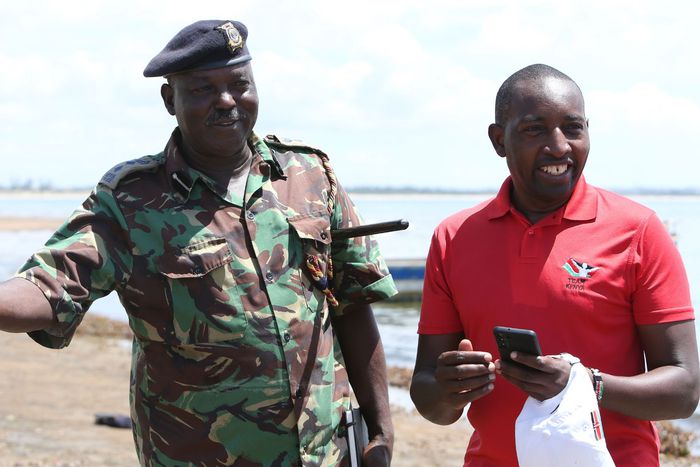 NOC-K Secretary General Francis Mutuku standing next to a policeman.
