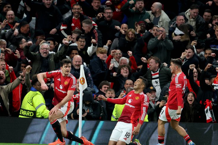 Harry Maguire celebrates Manchester United's winner against Lyon with teammates.