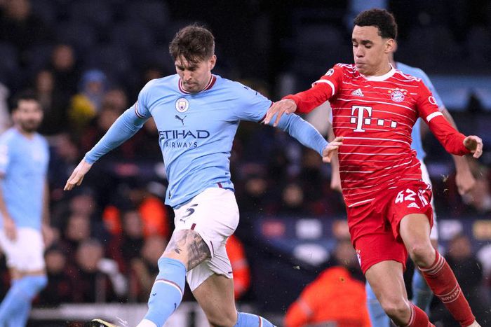 John Stones of Manchester City challenges Jamal Musiala of Bayern Munich.