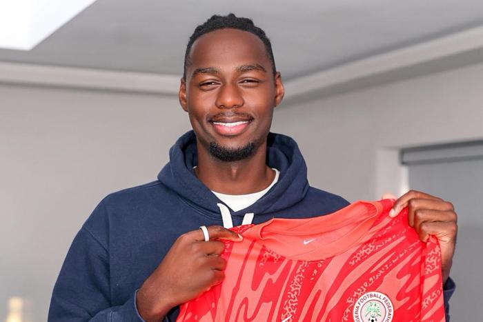 Arthur Okonkwo is holding the Super Eagles kit after his unveiling.