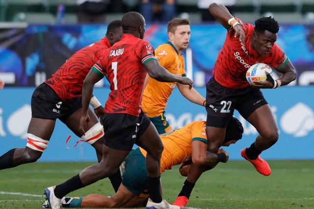 John Okoth trying to evade a tackle from one of the Australia players.
