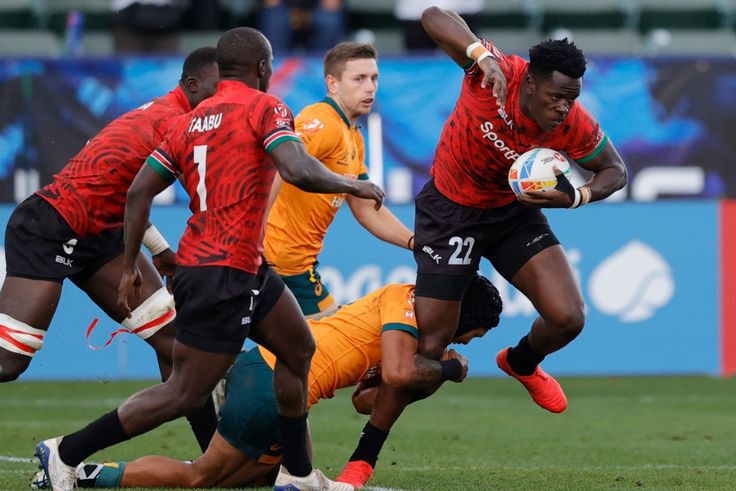 John Okoth trying to evade a tackle from one of the Australia players.