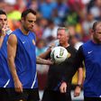 Federico Macheda (27) and Sir Alex Ferguson in the background , of Manchester United take a water break behind Dimitar Berbatov (9) and Wayne Rooney (10) during a practice session the day before the World Football Challenge match against FC Barcelona