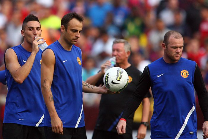 Federico Macheda (27) and Sir Alex Ferguson in the background , of Manchester United take a water break behind Dimitar Berbatov (9) and Wayne Rooney (10) during a practice session the day before the World Football Challenge match against FC Barcelona